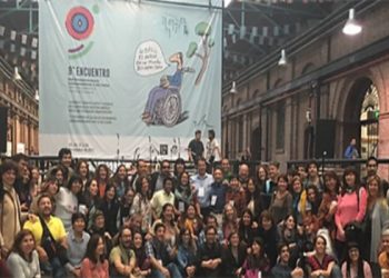 Fotografía del 9° Encuentro de la Red Interuniversitaria Latinoamericana y del Caribe sobre Discapacidad y Derechos Humanos realizado en la Universidad Nacional de Lanús (UNLA), año 2017. Descripción de imagen: Una multitud reunida en un edificio antiguo mira a cámara, arriba un banner de gran tamaño detalla “noveno encuentro”.